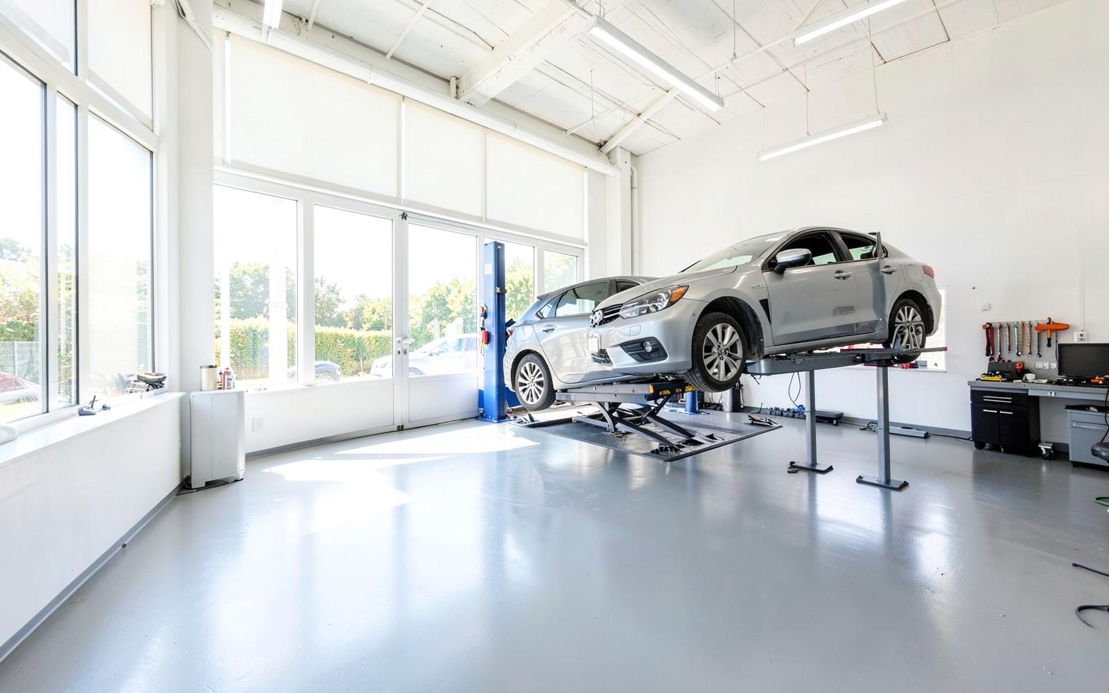 Atelier lumineux du garage Afellah Automobile à Trappes avec un véhicule sur pont élévateur